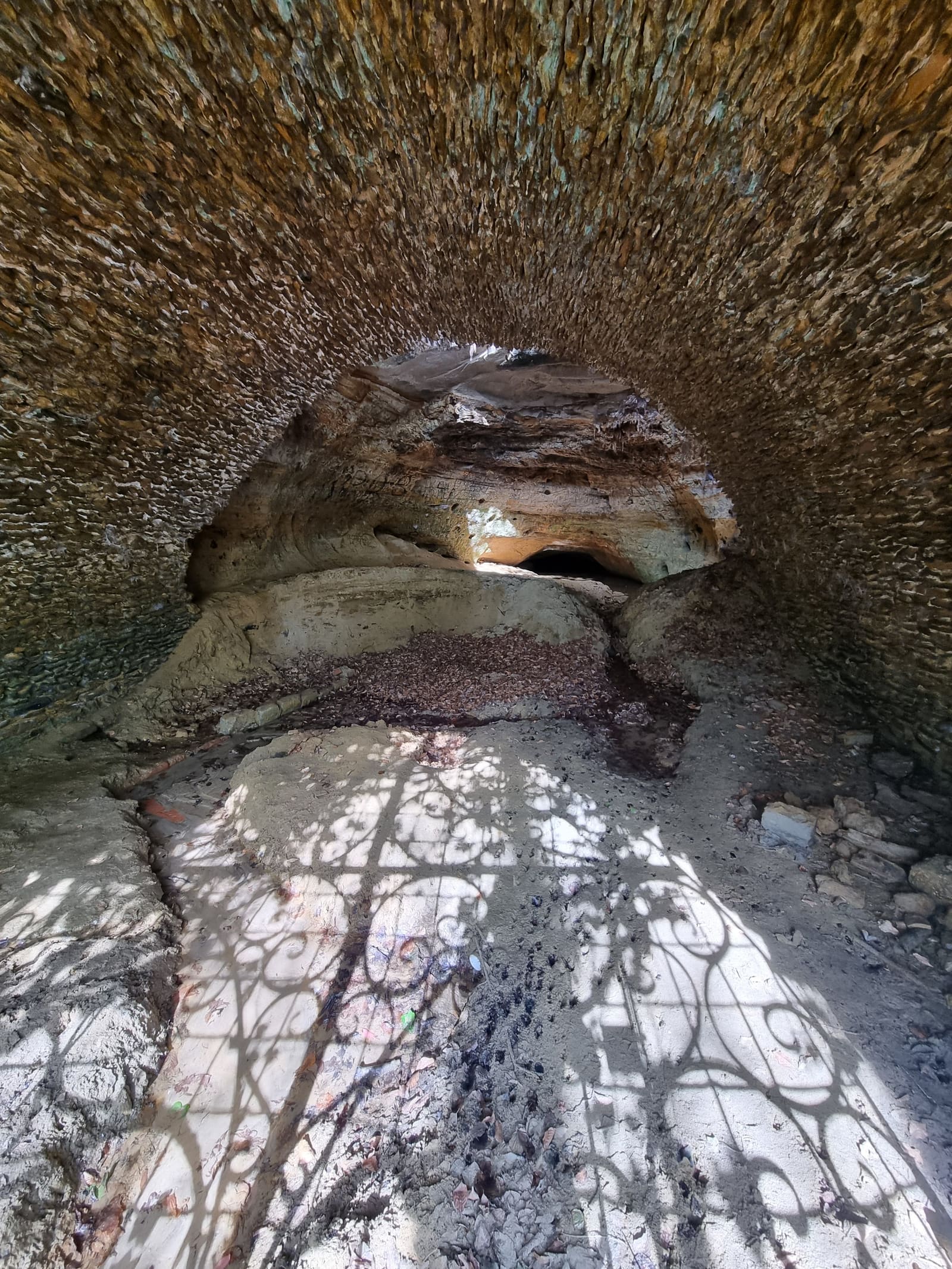 Gate shadows across the cave passage