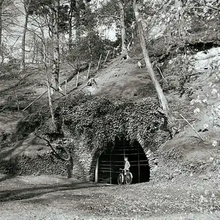 A visitor at the ivy-covered arch, mid-century