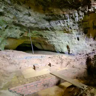 Inside the cave today: brickwork and pooling spring water